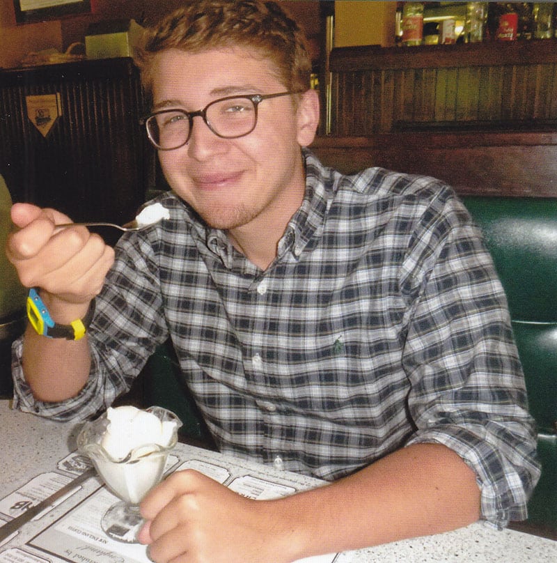 A young man enjoying a bowl of vanilla ice cream